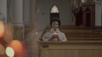 jung afrikanisch Frau mit lockig Haar beten Innerhalb Kirche video