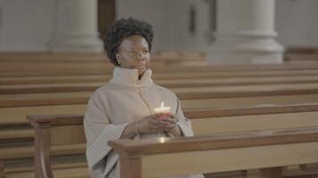 jovem africano mulher com encaracolado cabelo Rezar dentro Igreja video