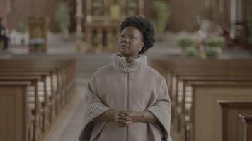 Jeune africain femme avec frisé cheveux prier à l'intérieur église video