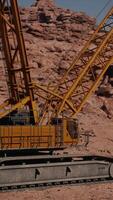 A large yellow crane sitting on top of a rocky hillside video