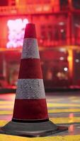 A red and white traffic cone sitting on top of a street video