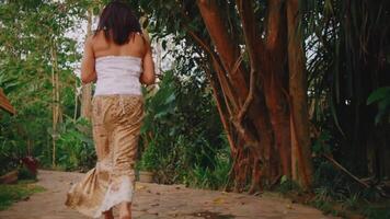 mulher corrida em uma rústico caminho de a rio, cercado de exuberante vegetação video