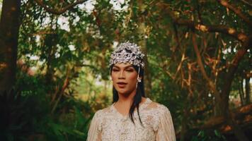 Elegant woman with floral headpiece in a lush forest setting. video