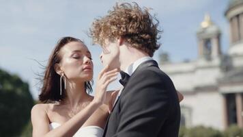 Beautiful couple of newlyweds look at each other. Action. Beautiful couple of newlyweds passionately look at each other. Newlyweds pose on windy sunny day in summer city video