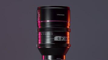 A huge camera lens. Action. A large portrait lens that rotates around itself on a gray background. video