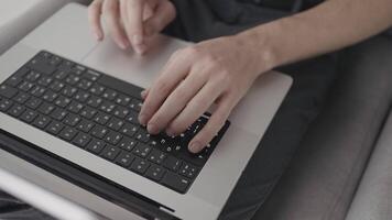 laptop toetsenbord. actie. een persoon zit Bij een computer en werken in modern conditie, dichtbij het schieten van de toetsenbord en de het drukken werkwijze. video
