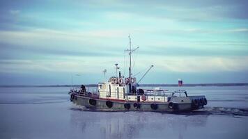 groß Lastkahn beim das Norden Pole. Clip. im das Vordergrund Seil mit Eiszapfen. im das Hintergrund, ein schwer Lastkahn im Eis Wasser ist im Fokus. ein Schiff ziehen ein Lastkahn im Abschleppen video