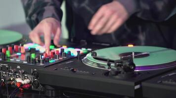 DJ mains sur le mélange console fermer. art. le dj est en jouant une musical ensemble. le gars pièces avec le sien la gauche main sur le table d'harmonie de le dj console video