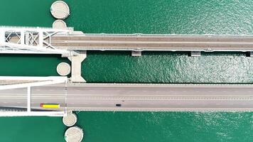 superiore Visualizza di grande ponte al di sopra di verde fiume. azione. grande bianca ponte con autostrada e in viaggio macchine. bellissimo turchese fiume con autostrada su ponte video