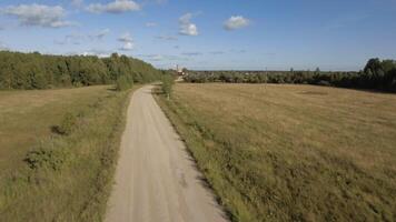 Grün Feld. Lager Filmaufnahme. enorm Felder mit trocken Gras Nächster zu das Straße hinter welche Sie können sehen das Stadt und das industriell Zone gegen das Blau Himmel. video