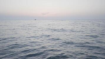 Beautiful long sea. Action. The undulating sea in the landscape against the background of a slightly misty sky, behind which ships sail in the distance. video