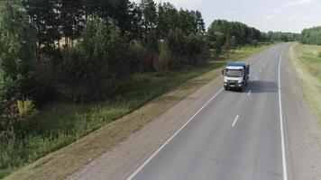 Saint Petersburg - Russia, 12.24.2021. Top view of truck driving on country highway in summer. Scene. Travel or move by truck along highway with beautiful fields and forests. Trip along country video