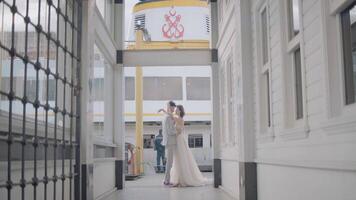 recién casados en antecedentes de muelle. acción. hermosa recién casados actitud Entre ciudad edificios elegante recién casados abrazo en antecedentes de ciudad muelle en nublado clima video