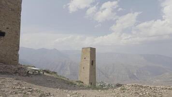 Mountain landscape with stone towers. Action. Stone fortress towers in mountains. Historical stone towers in mountains on background of sky video