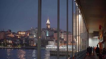 Turkey, Istanbul - October 10, 2021. View from panoramic windows on coast of night city. Action. Beautiful coast with glowing city lights of Istanbul evening from panoramic windows. Panoramic windows video