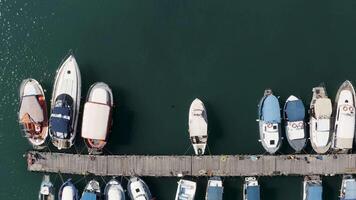 Aerial top view of the yachting bay and turquoise calm water surface with sun flares. Action. Boats and yachted moored by the pier. video