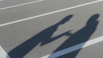 das Silhouetten von zwei jung Männer während wütend Konflikt. hdr. Schatten von streiten freunde mit jeder andere auf das Hintergrund von Parkplatz Asphalt. video