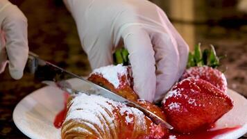 the chef cuts a delicious fresh croissant strawberry syrup around to get his hands dirty I want to lick fresh strawberries on the plate with his tongue show the structure of the puff pastry video