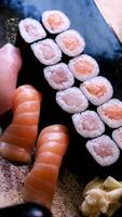 Front shot of a Japanese chef prepares a plate of sushi sashimi plate with raw fish in a sushi-bar. Closeup on hands. video