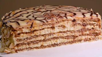 Piece of a puff pastry cake, sprinkled crumbs, with custard cream is placed with a cake spatula on a glass plate video