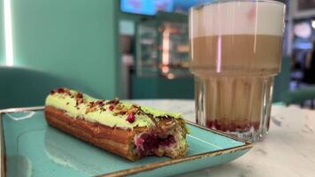 Hot lattes with foam Eclair with pistachios Eclairs with glaze, chocolate, nuts and pistachios no top, loop video