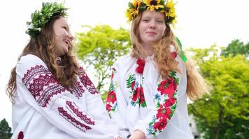 midsommar. två flickor i slavic kläder talande medan Sammanträde förbi de brand video