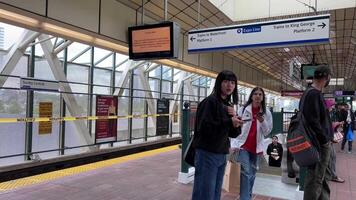 renovation of Sky Train station on Surray Central no entry exit Use same platform in both directions Be careful Do not cross the yellow line of inscription people waiting for train barrier 06.19.2023 video