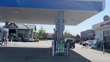 divisa a gás estação Onde a carro é reabastecido reabastecimento processo derramando gasolina máquina pessoas vida dentro a cidade Canadá Vancouver Surrey 2023 video