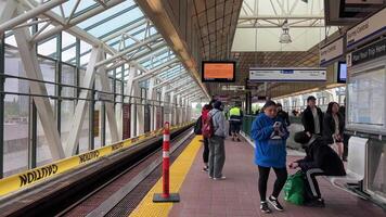 renovation of Sky Train station on Surray Central no entry exit Use same platform in both directions Be careful Do not cross the yellow line of inscription people waiting for train barrier 06.19.2023 video