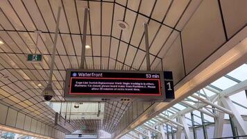 renovation of Sky Train station on Surray Central no entry exit Use same platform in both directions Be careful Do not cross the yellow line of inscription people waiting for train barrier 06.19.2023 video