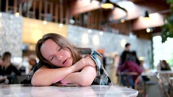 Sleepy Woman Having a Coffee at the Restaurant. Yawning girl addicted to caffeine in need for her cup in the morning video