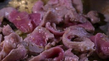 Close-up of sliced raw beef meat in frying pan video