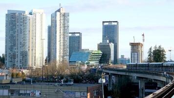 blu linea skytrain capolinea nel Surrey treno In arrivo a partire dal vancouver re Giorgio treno lentamente si avvicina gabbiani volante molti uccelli al di sopra di il città grattacieli bellissimo edifici paesaggio urbano panorama video