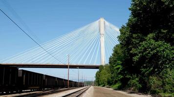 Port Mann Bridge over the Fraser River. Sunny Summer Surrey, Vancouver, shot of prohibited area from side mass of railway close-up approach against background of blue sky white cables are stretched video