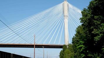 port mann bridge canada over the Fraser River in BC interesting unusual footage of bridge from bottom up green trees railroad Earth on siphon of blue cloudless sky background for advertising text video