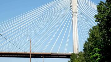 port mann bridge canada over the Fraser River in BC interesting unusual footage of bridge from bottom up green trees railroad Earth on siphon of blue cloudless sky background for advertising text video