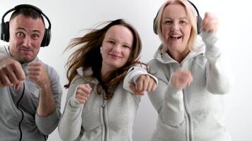 cheerful sports family boxing with fists at the camera in headphones listening to music dancing man girl woman making faces laughing outstretched fists defending white background video