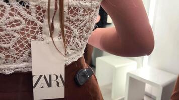 branco openwork topo e Castanho calça vestido de uma Adolescência menina dentro uma loja Zara dentro a apropriado quarto tiro belas fechar-se 06.04.22 Paris França Zara fazer compras video