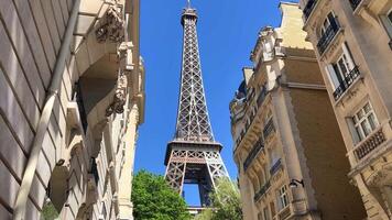 Paris Eiffel Tower An interesting angle to the Eiffel Tower, unusual from the side of beautiful buildings Eiffel tower against a blue sky without clouds Clear sky France Paris video