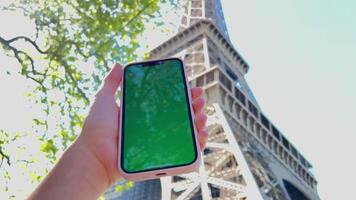 un mujer mano con vitiligo sostiene teléfono inteligente con verde pantalla. espalda ver disparo. croma llave, cerca arriba mujer mano participación teléfono con vertical verde pantalla. video