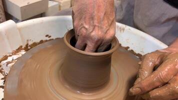 Working with a potter's wheel master class female hands Show how to make an object out of clay Also leveling with a clay sponge inside the finished item but still damp and wet Relax and art video