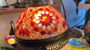 Bright multi-colored Turkish lamps hang in the store shine in different colors mosaic Colored stars and flowers painted on the lamps themselves They look like a light ball video