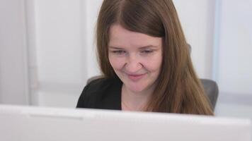 long hair black clothes white computer laptop young woman sits at a computer at the reception of a white light office hospital dentistry any computer programmers video