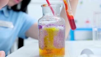 Hinzufügen rot Flüssigkeit zu ein Glas Flasche mit Orange Farbe Luftblasen Lehren ein Kind zu tun Chemie Experimente im ein Labor Labor Assistent klassisch Lernen Werkzeuge nehmen ein Blut Prüfung video