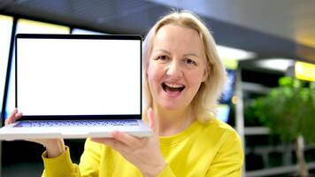 Bij de trein station vrouw Holding een laptop met een wit scherm tonen glimlachen adverteert beven haar hoofd Ja zegt prima Wauw bedrijf team sharing wereld economie verslag doen van document laptop in cafe. video