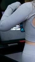 schön glücklich lächelnd sportlich aktiv schlank jung Frau tun Gehen Übungen auf Laufen Spur und genießen Musik- im Kopfhörer während Abend Zuhause trainieren video