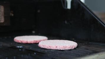 Frozen cutlets Dolly shot of frozen hamburger patties and ingredients lying on kitchen table next to electric grill video