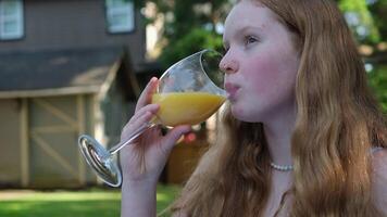 meisje drankjes oranje sap Aan de straten passie fruit limonade. zomer drankje. meenemen limonade. verkoudheid limonade met ijs in een vrouw hand- tegen een rivier- visie. dansen met een drinken in hand- video