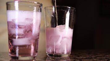 verser Rose du vin dans une verre proche en haut de verser rouge du vin de bouteille dans gobelet sur foncé Couleur Contexte mur dans studio. lent mouvement video