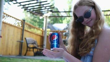 Trinken Pepsi Mädchen mit rot Haar im Sonnenbrille zeigt an Daumen oben ziemlich Klasse Getränke Coca Cola trinken Pepsi video